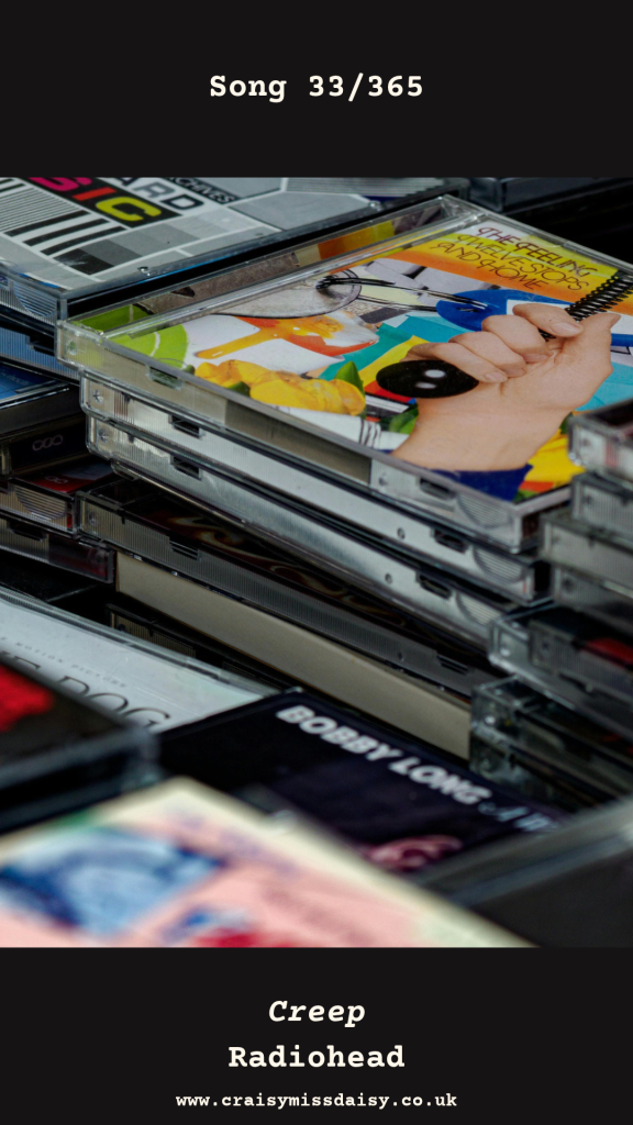 Black graphic featuring a photograph of a retro stacked CD case pile for Song 33/365, Creep by Radiohead.